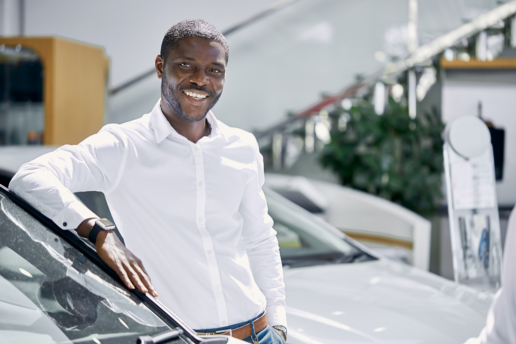 Man standing next to his car and smiling